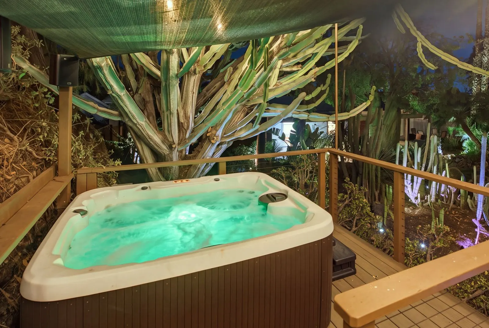 The hot tub glowing on the garden deck at night